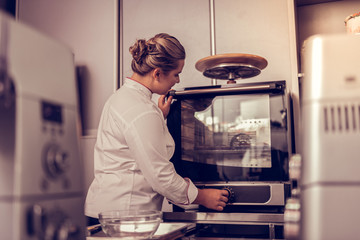 Wall Mural - Professional skilled cook turning on the oven