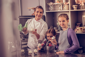 Wall Mural - Nice concentrated girl looking at the cupcake