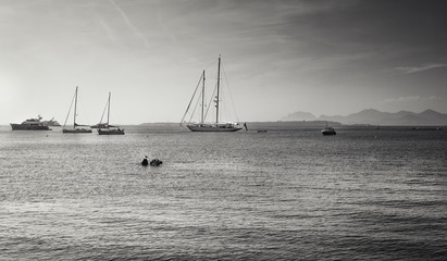 Wall Mural - Black and white picture of the yachts and sailboats at anchor in Golfe Juan at the French beach resort of Juan-les-Pins with the island Ile Sainte-Marguerite in the background