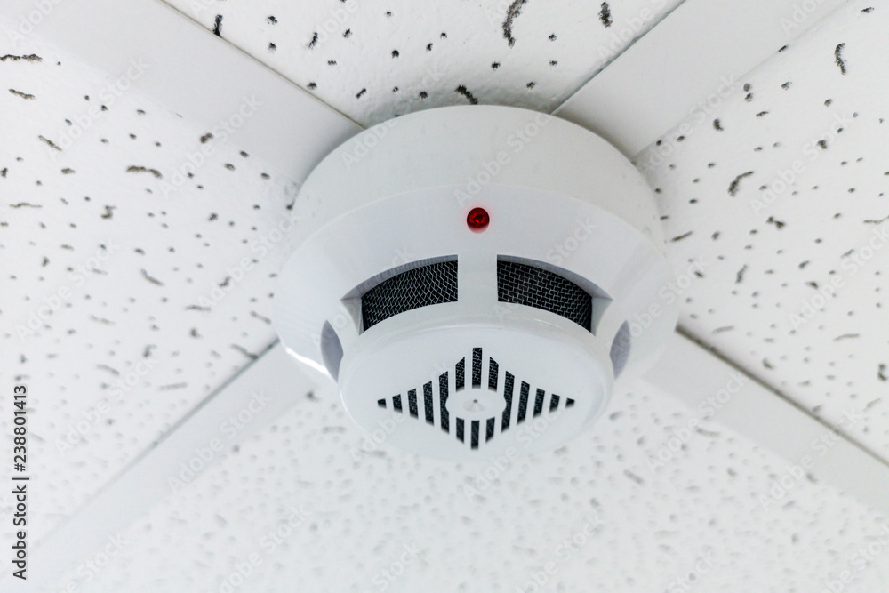 Modern smoke sensor hanging on ceiling. Temperature gage circular wall.The wall of the smoke sensor on the ceiling of the circular