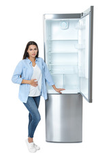 Wall Mural - Hungry woman near empty refrigerator on white background