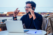 © yurakrasil - man talking on the phone india summer holidays.stylish young indian male freelancer working with laptop freelance surfing online.businessman at remote work on the beach.dream job.online purchase sale