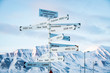 Big pole with directions signs and distances to cities of the world. Blue sky, mountains covered with snow. Longyearbyen, Spitsbergen, Norway