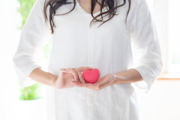 young asian woman holding heart symbol