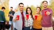 celebration, friendship and people concept - group of smiling friends toasting non alcoholic drinks in party cups over rooftop background