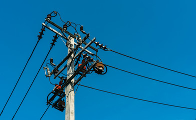 High voltage electric pole and transmission lines with clear blue sky. Electricity pylons. Power and energy engineering system. Danger high voltage tower. Cable wire on electric post. Power industry.