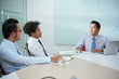 © DragonImages - Vietnamese company CEO meeting with employees at big office table
