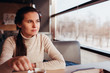 © Arsentyev Vladimir - The woman has a rest in cafe, sits at a table with a cup of tea