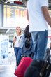 © lightpoet - Young woman with her luggage at an international airport, before going through the check-in and the security check before her flight