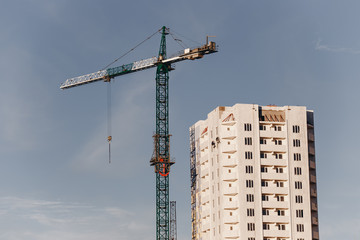 View of the construction site with crane and high-rise residential building