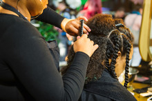 Close Up African Hairstylist Braided Hair Of Afro American Female Client In The Barber Salon. Black Healthy Hair Culture And Style. Stylish Therapy Professional Care Concept. Selective Focus.