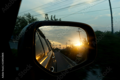 Fotografía Side view of car mirror the backdrop in rural countryside with evening sunshine shines