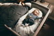 Top view of a baby sleeping in a bedside crib