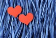 © Owl_photographer - Red painted wooden hearts on blue paper raffia background