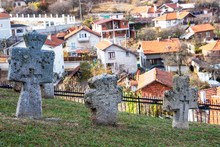 Ancient Stone Crosses At The Churchyard Of St. Petka Eastern Orthodox Church In Tsari Mali Grad Fortress, The Village Of Belchin, Bulgaria In The Background