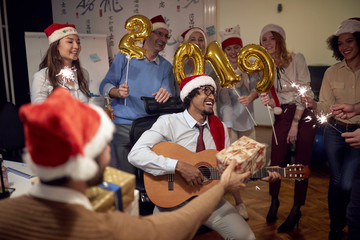 Happy business group people in Santa hat having fun for celebrity Christmas party with song..