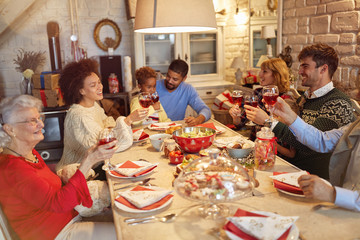 large family clinking glasses on Christmas dinner and enjoy in holidays.