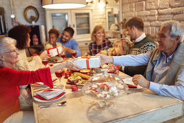 Wall Mural - family and friends enjoy on Christmas dinner and exchange gifts together.