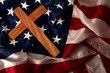 Evangelical America, christianity, born again christian and fundamentalist religious right concept with close up on a wooden cross or crucifix on the american flag with dramatic light and moody tone