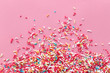 © SEE D JAN - Colorful sprinkles on a pink background, top view with copy space