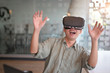 © Prathankarnpap - Worker Man wearing virtual reality goggles in modern office with relax time excited technology concept.