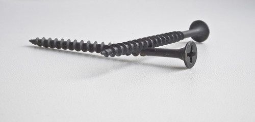 Isolated object - two black wood screws on a light background