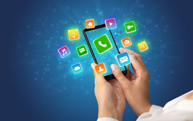 Female hand using smartphone with 3D shiny starlike application icons around
