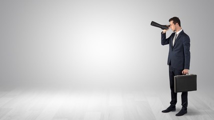 Wall Mural - businessman looking forward with binoculars in an empty space