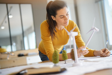 Stunning wind turbine engineer with cellphone planning wind farm placement