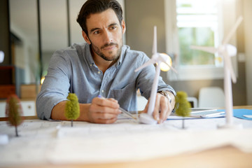 Handsome wind turbine engineer working in modern office