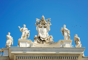 Detail from baroque Saint Peter's colonnade with beautiful statues of saints and Pope Alexander VII coat of arms. Vatican City (Rome, Italy)