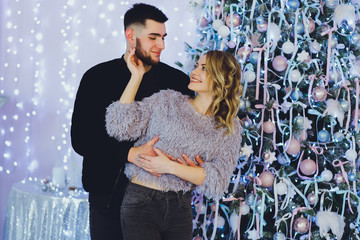 Wall Mural - Couple in love: a guy and a girl on the background of the Christmas tree? Christmas background