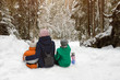 © somemeans - Mom with two sons are hugging against the background of snow-covered forest. Winter cloudy day. Back view