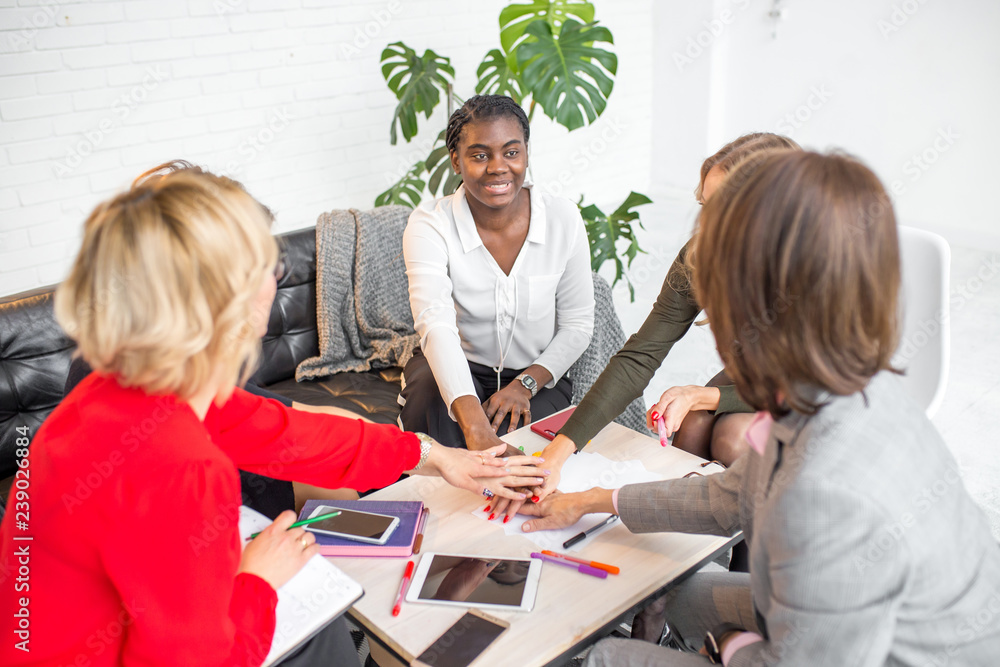 Photo Stock Motivated excited multiracial female team giving high five ...