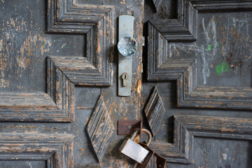 An old wooden hinged door and a hinged lock.