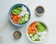 © Nata Bene - Salmon poke bowl with fresh fish, rice, cucumber, avocado with black and white sesame. White marble table. Food concept.
