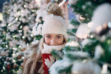 Young female with new year illuminated tree looking camera