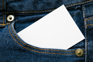 blank white paper or card in front pocket of blue jeans with copyspace for sale text or business concept