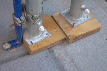 leveling off construction scaffolding with wood pegs and nails