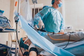 Wall Mural - Process of gynecological surgery operation using laparoscopic equipment. Group of surgeons in operating room with surgery equipment