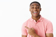Portrait of impressed delighted and surprised charismatic handsome african american young male in pink shirt pointing backwards or left with happy excited smile, being under impression over gray wall
