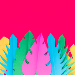 Wall Mural - Multicolored paper tropical leaves on a bright pink background with a blank space for text. Minimal, Flat lay