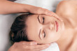 © Peakstock - woman enjoying a relaxing head massage at spa salon