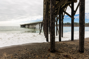  Waves breaking on the poles under the pier of San Simeon, California, USA