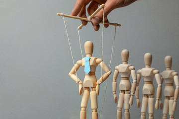 Leader puppet activist and workers. Concept of how to manage leader in team. Doll in tie on the ropes controlled by hand and crowd of people employees