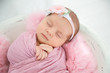 Adorable newborn girl lying in baby nest, closeup