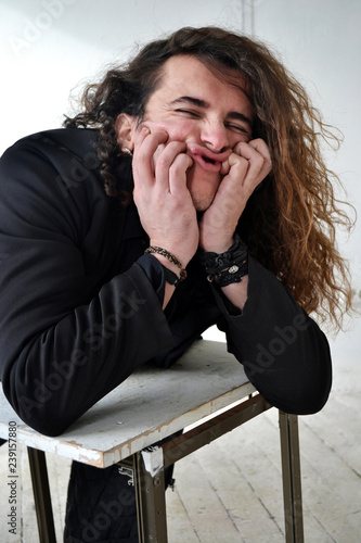 Portrait Of Actor With Long Curly Hair In Black Clothes Posing