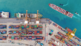 Aerial top view container ship at sea port and working crane bridge loading container for import export, shipping or transportation concept background.