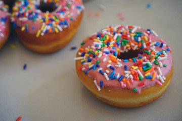 Wall Mural - Fresh donuts with pink icing and colorful sprinkles