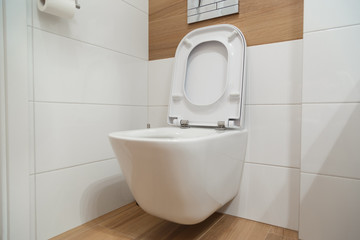 White toilet on the wall with opened lid.